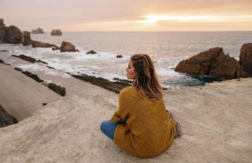 ep mujer joven sentada junto al mar