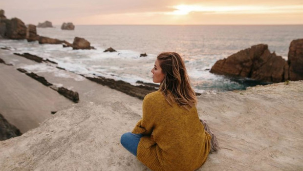 ep mujer joven sentada junto al mar