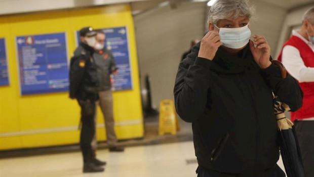 ep un pasajero se coloca la mascarilla que previamente le han repartido voluntarios de la cruz roja