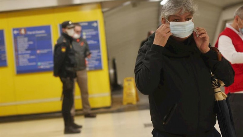 ep un pasajero se coloca la mascarilla que previamente le han repartido voluntarios de la cruz roja
