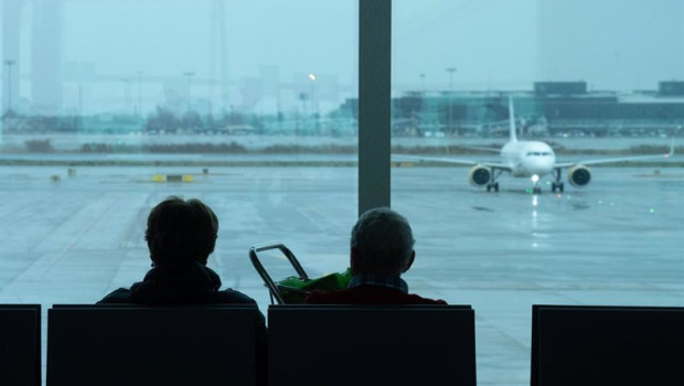 ep archivo   dos personas esperan sentadas frente a un avion aparcado en la pista del aeropuerto de