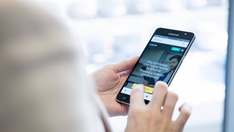 ep archivo   una persona maneja en su movil la aplicacion de popcoin el roboadvisor de bankinter