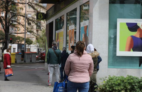 ep personas en fila guardan su turno para entrar en una oficina de bankia