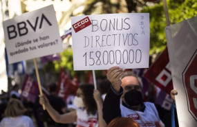ep un hombre sujeta un cartel en el que se lee bonus directivos 158000000 durante una concentracion