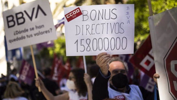 ep un hombre sujeta un cartel en el que se lee bonus directivos 158000000 durante una concentracion