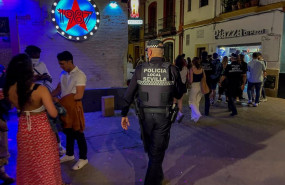 ep un policia municipal de sevilla le recrimina a un joven que esta esperando a la puerta de una