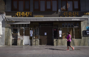 ep una mujer pasa junto al cartel en el cierre de la cafeteria atalaya en la localidad de peralta en