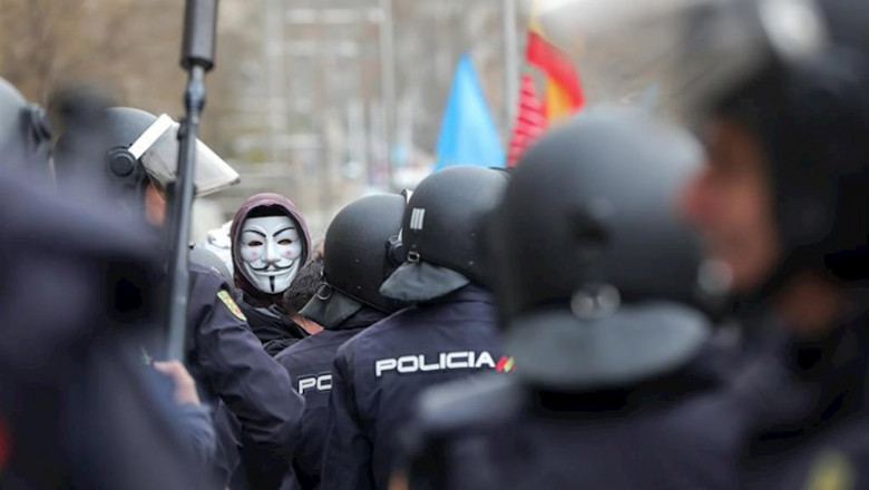 Agentes de la Policía Nacional frente a los manifestantes con máscaras de Anonymous y banderas de España en las inmediaciones del Congreso | Jesús Hellín - Europa Press ep agentes de la policia nacional frente a los manifestantes con mascaras de anonymous y banderas de
