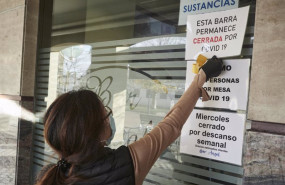ep un camarera coloca un cartel de barra cerrada por covid en un bar afectado por restricciones de