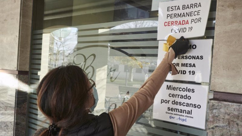 ep un camarera coloca un cartel de barra cerrada por covid en un bar afectado por restricciones de