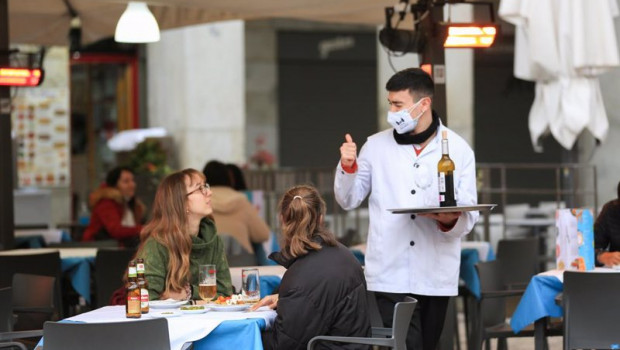 ep archivo - un camarero atiende a dos clientas en la terraza de un bar