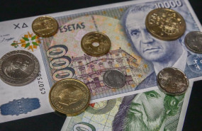 ep varias monedas encima de dos billetes de las antiguas pesetas a 15 de junio de 2021 en madrid
