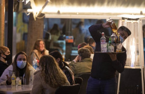 ep un camarero atendiendo las mesas de una terraza