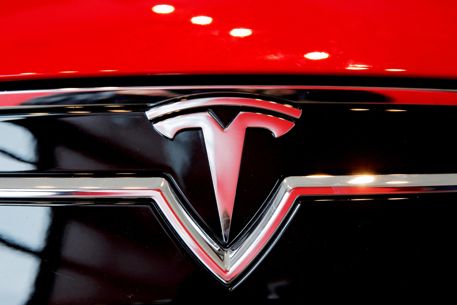 un logo tesla sur une model s a l interieur d une concession tesla a new york 