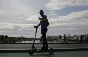 ep imagenes de recursos de patinetes electricos joven paseando por el puente de triana en patinete