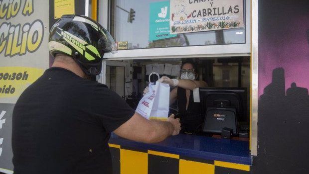 ep una persona recoge un pedido de comida para llevar en un bar