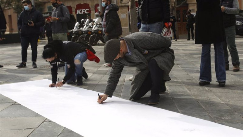 Archivo - Un grupo de personas pintan una pancarta durante una manifestación convocada en la Plaza España de Palmapara reclamar la apertura de la restauración. | Isaac Buj - Europa Press - Archivo ep archivo un grupo de personas pintan una pancarta durante una manifestacion convocada en la