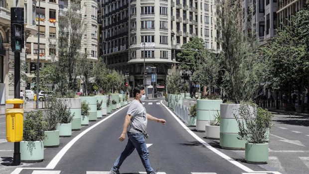 ep un hombre cruza por un paso de cebra al lado de los maceteros colocados en la plaza del
