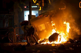 ep un manifestante frente a un contenedor que arde durante los disturbios en la plaza de urquinaona