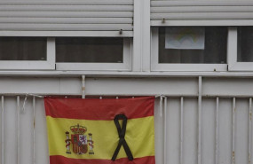 ep una bandera de espana colgada en un balcon con un crespon negro en recuerdo a los fallecidos por