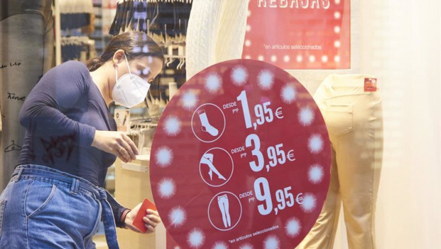 ep una dependienta termina de poner los carteles de rebajas en su negocio durante el primer dia de