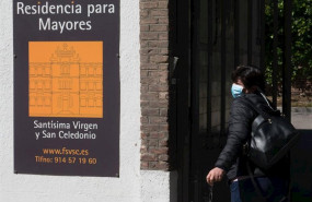 ep una trabajadora protegida con mascarilla entra por la puerta de la residencia santisima virgen y