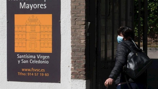 ep una trabajadora protegida con mascarilla entra por la puerta de la residencia santisima virgen y
