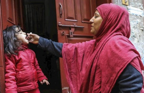 ep una trabajadora sanitaria vacuna a una nina de 4 anos contra la polio en la puerta de su casa en