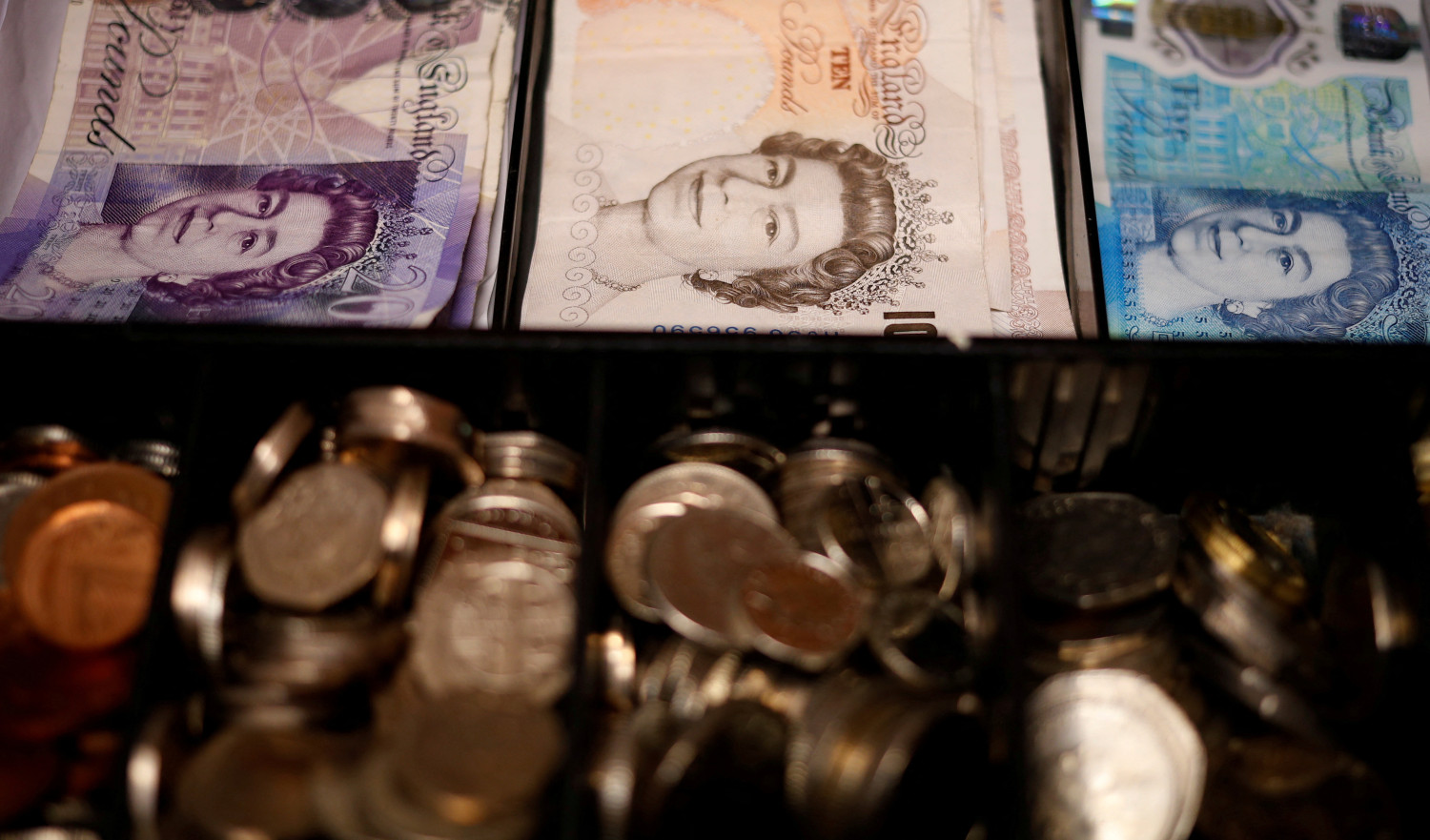des billets et des pieces de monnaie en livres sterling dans une caisse enregistreuse a manchester en grande bretagne 