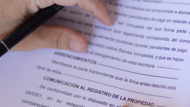 ep archivo   una mujer con una escritura de compraventa en un notario
