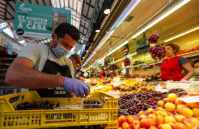 ep un hombre trabaja colocando la fruta en una una fruteria del mercado central de valencia