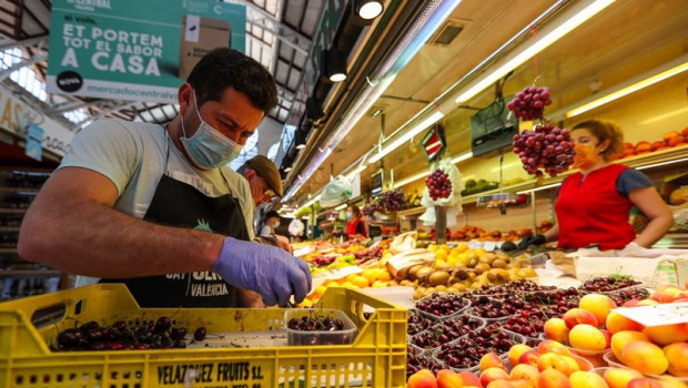 ep un hombre trabaja colocando la fruta en una una fruteria del mercado central de valencia