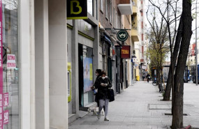 ep una mujer con mascarilla espera su turno frente a una sucursal de bankia