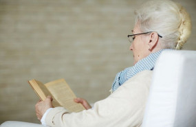 concentrated retired woman reading old book