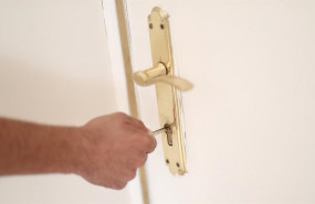 ep un hombre introduce una llave en la cerradura de la puerta de una vivienda