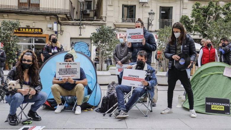 ep varias personas que trabajan en el ocio nocturno con carteles durante una acampada para reclamar