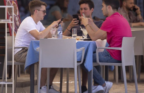 ep tres hombres comen en una terraza del centro de la capital