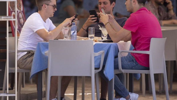 ep tres hombres comen en una terraza del centro de la capital