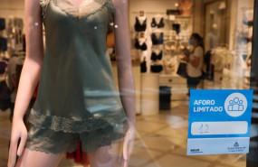 ep cartel en la entrada de una tienda de ropa interior en el que se indica que el aforo esta