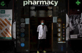 ep un farmaceutico protegido con mascarilla en la puerta de una farmacia durante el segundo dia