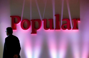 ep file photo a man stands next to the logo of spains banco popular during the banks results