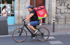 ep fotografia de un repartidor de la empresa de reparto just eat transitando en bicicleta por una