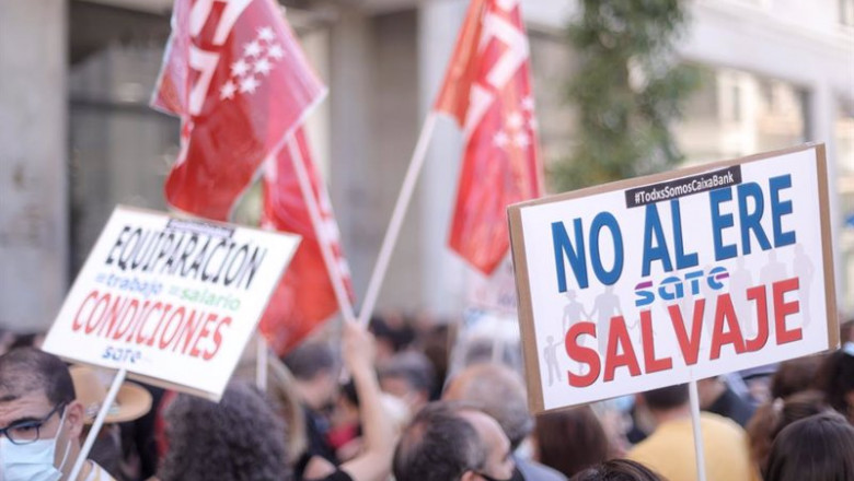 Un grupo de personas levanta pancartas durante una concentración de trabajadores de Caixabank frente al Hotel Riu Plaza España durante su segunda jornada de huelga, a 29 de junio de 2021, en Madrid (España). La plataforma de unidad sindical, conformada po | Eduardo Parra - Europa Press ep un grupo de personas levanta pancartas durante una concentracion de trabajadores de caixabank