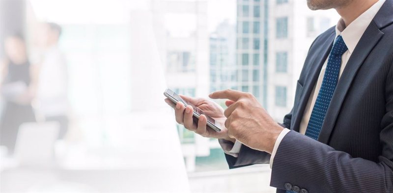 Un ejecutivo mirando su teléfono móvil | FACEPHI ep un ejecutivo mirando su telefono movil