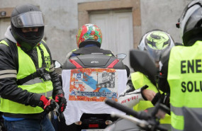 ep un hombre lleva enganchada a su moto una pancarta donde se lee a marina se salva luchando antes