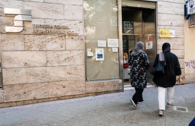 ep varias personas migrantes esperan en el exterior de una oficina de la seguridad social para