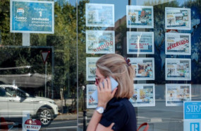 ep archivo   una mujer camina frente a un escaparate de anuncios de viviendas