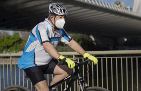 ep un ciclista protegido con mascarilla en el dia en que el gobierno permite salir a hacer deporte