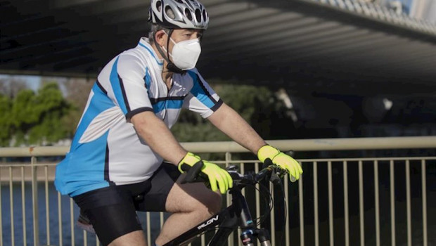 ep un ciclista protegido con mascarilla en el dia en que el gobierno permite salir a hacer deporte