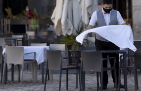 ep un camarero prepara la mesa de una terraza de un establecimiento
